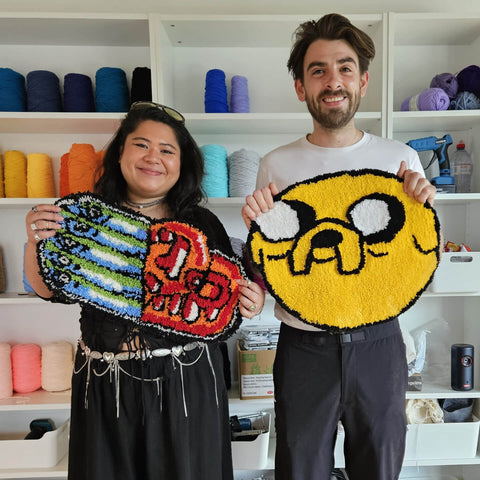 Two people holding adventure time rugs they made in craft studio London tufting workshop