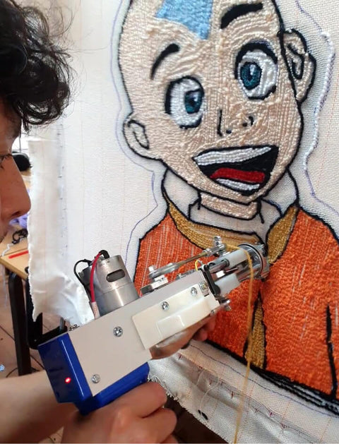 Person using a tufting using tufting gun to make a avatar aang character rug.