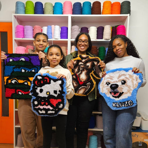 Family of Four holding Colourful tufted rugs and smiling at craft studio london