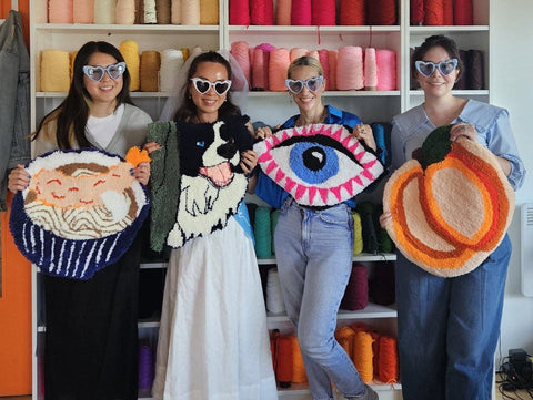 Hen party guests holding finished handmade rugs at Craft Studio London