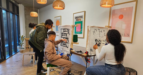 First-time tufting workshop participants at Craft Studio London using a tufting gun to bring their rug designs to life