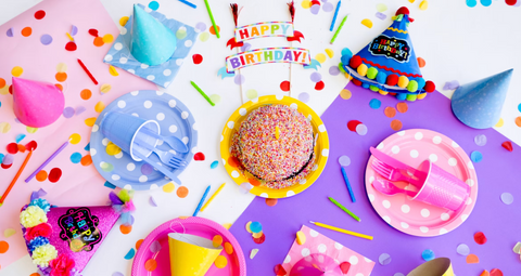 Birthday cake with a happy birthday sign and party hats all around