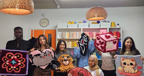 Group of guests holding finished handmade rugs at a fun London tufting workshop at Craft Studio London