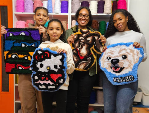 Family of Four holding Colourful tufted rugs and smiling at craft studio london