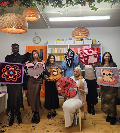 Guests holding handmade tufted rugs at Craft Studio London
