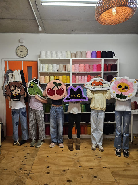 Rug making class guests holding finished handmade rugs in London